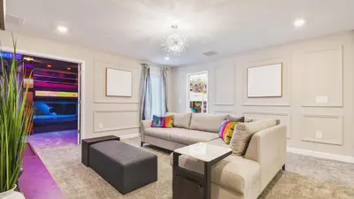 a living room with a couch and a table at Storey Lake 10BR Lakeview Home Pool/SPA Game Room in Kissimmee