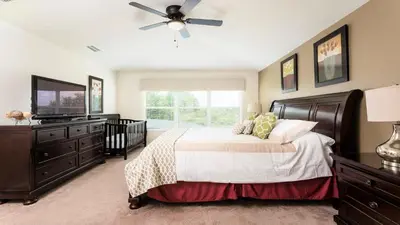 a bedroom with a bed and a ceiling fan at Windsor Hills 6br Cozy Home Pool/Spa 2miles Disney in Orlando