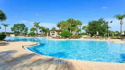 a large swimming pool at a resort with palm trees at Windsor Hills 6br Cozy Home Pool/Spa 2miles Disney in Orlando