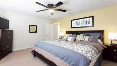a bedroom with a bed and a ceiling fan at Windsor Hills 6br Cozy Home Pool/Spa 2miles Disney in Orlando