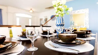 a table with plates and glasses and a vase with flowers at 6BR Private Pool, Spa, Gameroom, Close to Disney in Orlando