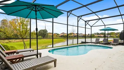 a swimming pool with benches and an umbrella at Opulent Retreat, Pool & Lake View, Near Parks in Kissimmee