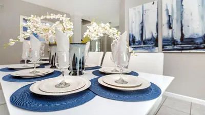 a table with blue and white plates and wine glasses at Windsor Hills 7BR Villa Pool SPA Disney Greenview in Orlando