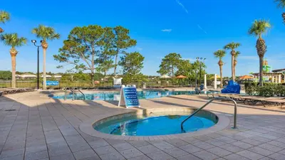 a small pool with palm trees in a park at Windsor Hills 7BR Villa Pool SPA Disney Greenview in Orlando