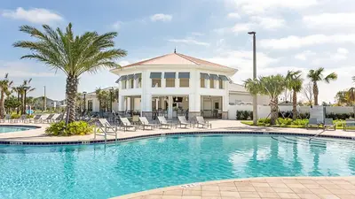 a pool in front of a house with palm trees at Family Reunion 10BR Villa Pool/SPA Near Disney! in Kissimmee