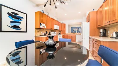 a kitchen with a glass table and blue chairs at Windsor Hills 5br Private Pool, Near Disney in Orlando