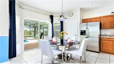 a kitchen with a table and chairs and a refrigerator at Home with Lakeview Close to Disney w Pool in Orlando
