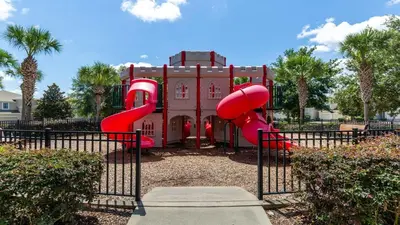a playground with a red slide in front of a building at Home with Lakeview Close to Disney w Pool in Orlando