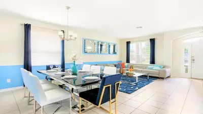 a dining room and living room with a table and chairs at Home with Lakeview Close to Disney w Pool in Orlando