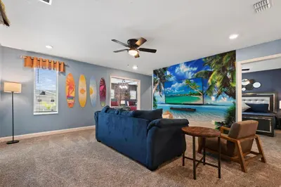 a living room with a blue couch and a ceiling fan at Lakeview Villa Near Disney with Pool & Resort in Kissimmee