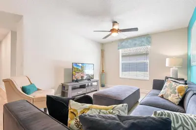 a living room with a couch and a tv at Lakeview 6BR Cozy Home Pool/SPA,Steps to Waterpark in Kissimmee