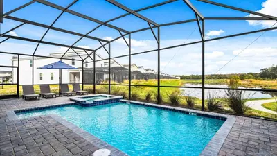 a large swimming pool with a glassconservatory at Lakeview 10BR Home Pool/SPA Game Room Disney Theme in Kissimmee