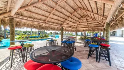 a patio with tables and chairs and a swimming pool at Lakeview 10BR Home Pool/SPA Game Room Disney Theme in Kissimmee