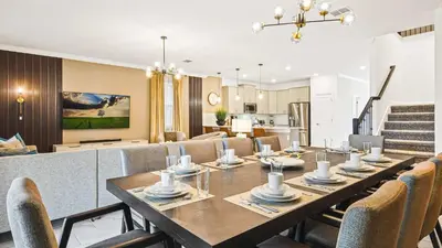 a dining room and living room with a table and chairs at Lakeview 10BR Home Pool/SPA Game Room Disney Theme in Kissimmee