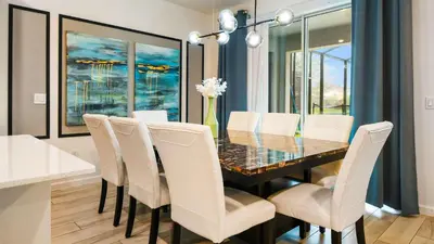 a dining room with a glass table and white chairs at Veranda Palms Lakeview 6br Villa Pool Spa, Disney in Kissimmee
