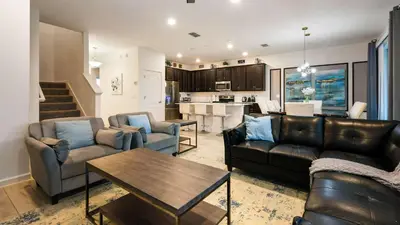 a living room with couches and a table and a kitchen at Veranda Palms Lakeview 6br Villa Pool Spa, Disney in Kissimmee