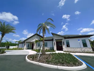 a house with a palm tree in a driveway at Storey Lake 5br Family Townhome w Pool Near Disney in Kissimmee
