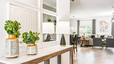 a living room with two potted plants on a table at Storey Lake 5br Family Townhome w Pool Near Disney in Kissimmee