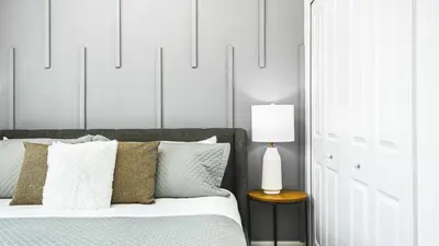 a bedroom with a bed with pillows and a lamp at Storey Lake 5br Family Townhome w Pool Near Disney in Kissimmee