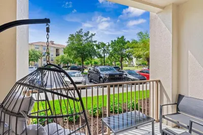 a balcony with a swing and a car parking lot at The Epic London Vista Cay Orlando Next to the club in Orlando