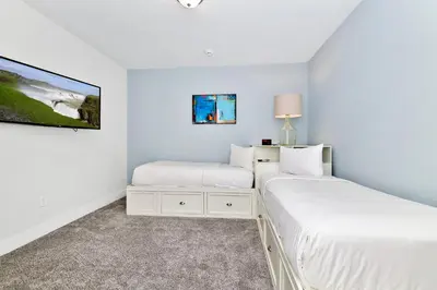 two beds in a bedroom with white walls at Elegant Home With Private Pool, Waterpark & Resort Access Near Disney At Encore Resort - 7610Wi in Kissimmee