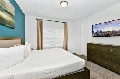 a bedroom with a white bed and a tv at Elegant Home With Private Pool, Waterpark & Resort Access Near Disney At Encore Resort - 7610Wi in Kissimmee