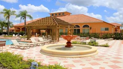 a fountain in a courtyard with chairs and a house at Game Room 12BR Kids World Pool Spa Near Disney in Kissimmee