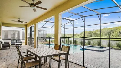 a large conservatory with a table and chairs and a pool at Storey Lake 9BR Lakeview Home Pool/SPA/Game Disney in Kissimmee