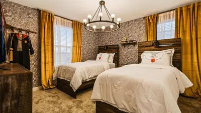 a bedroom with two beds and a chandelier at Storey Lake 9BR Lakeview Home Pool/SPA/Game Disney in Kissimmee