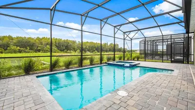 an indoor swimming pool with a clear glass building at Storey Lake 9BR Lakeview Home Pool/SPA/Game Disney in Kissimmee
