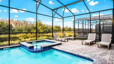 a swimming pool in a building with two chairs at Themed Rooms & Pool in Storey Lake Resort in Kissimmee