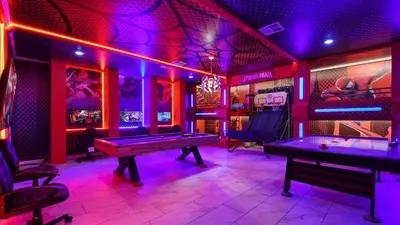 a room with two pool tables and purple lights at Themed Rooms & Pool in Storey Lake Resort in Kissimmee
