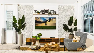 a living room with two chairs and a tv on a wall at Themed Rooms & Pool in Storey Lake Resort in Kissimmee