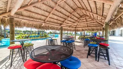 a patio with tables and chairs and a swimming pool at Cozy Home Storey Lake Resort Pool Spa Near Disney in Kissimmee