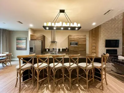 a kitchen with a table with chairs and a kitchen with a refrigerator at 3059 Luxury And Relaxation Just 1 Mile From Disney in Orlando