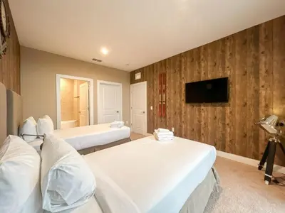 a bedroom with two beds and a tv on the wall at 3059 Luxury And Relaxation Just 1 Mile From Disney in Orlando