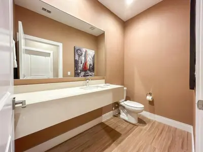 a bathroom with a toilet and a sink and a mirror at 3059 Luxury And Relaxation Just 1 Mile From Disney in Orlando