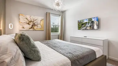 a bedroom with a large bed and a window at Luxury Home: Pool, Theater, Near Disney in Kissimmee