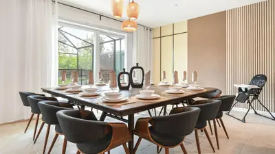 a dining room with a large wooden table and chairs at Luxury Home: Pool, Theater, Near Disney in Kissimmee
