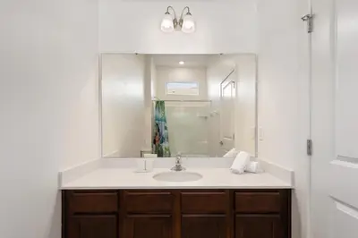 a bathroom with a sink and a mirror at Mario 12BR Villa w/ Private Green View Pool in Kissimmee