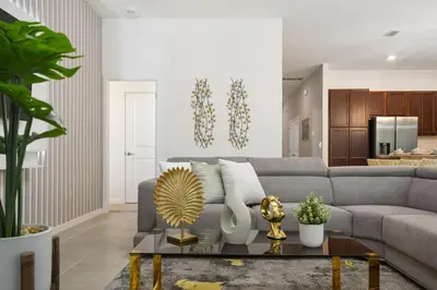 a living room with a gray couch and a table at Mario 12BR Villa w/ Private Green View Pool in Kissimmee