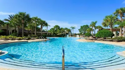 a large swimming pool with palm trees in a resort at Firework view 6BR Home Pool/Spa/Game Near Disney! in Orlando