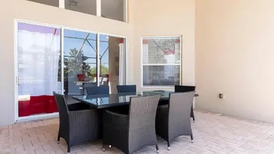 a dining room with a glass table and chairs at Windsor Hills 6BR Villa Pool/SPA Close to Disney in Orlando