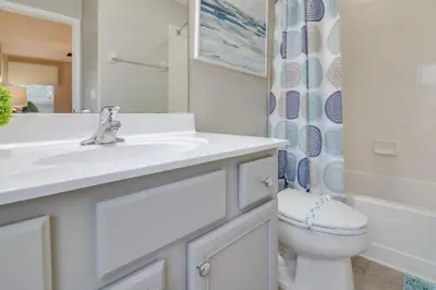 a white bathroom with a sink and a toilet at Emerald Escape in Kissimmee