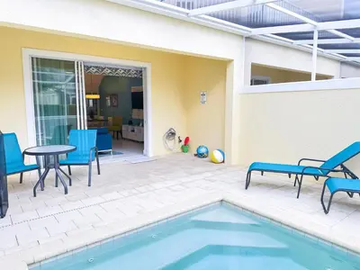a patio with a table and chairs and a pool at 3 bedrooms pool home Retreat Close to Disney in Orlando