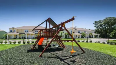 a playground with an orange swing in a yard at 3 bedrooms pool home Retreat Close to Disney in Orlando