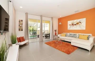 a living room with a white couch and an orange wall at 3 bedrooms pool home Retreat Close to Disney in Orlando