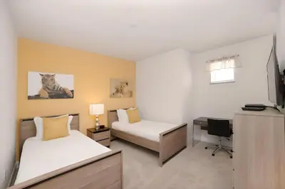 a bedroom with two beds and a desk with a computer at 3 bedrooms pool home Retreat Close to Disney in Orlando