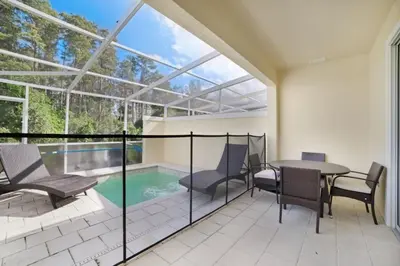 a patio with a table and chairs and a swimming pool at 3 bedrooms pool home Retreat Close to Disney in Orlando