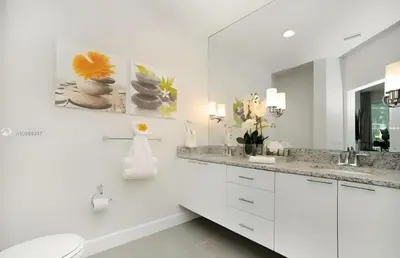 a white bathroom with two sinks and a mirror at 3 bedrooms pool home Retreat Close to Disney in Orlando